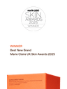 Award graphic for the Marie Claire UK Skin Awards 2025, showing a white circular badge at the top and text reading 'Winner Best New Brand Marie Claire UK Skin Awards 2025' on a dark green background, with part of an orange product box visible at the bottom.