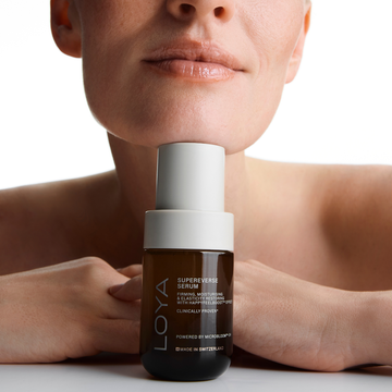 LOYA Supereverse Serum bottle held by a person with a neutral background